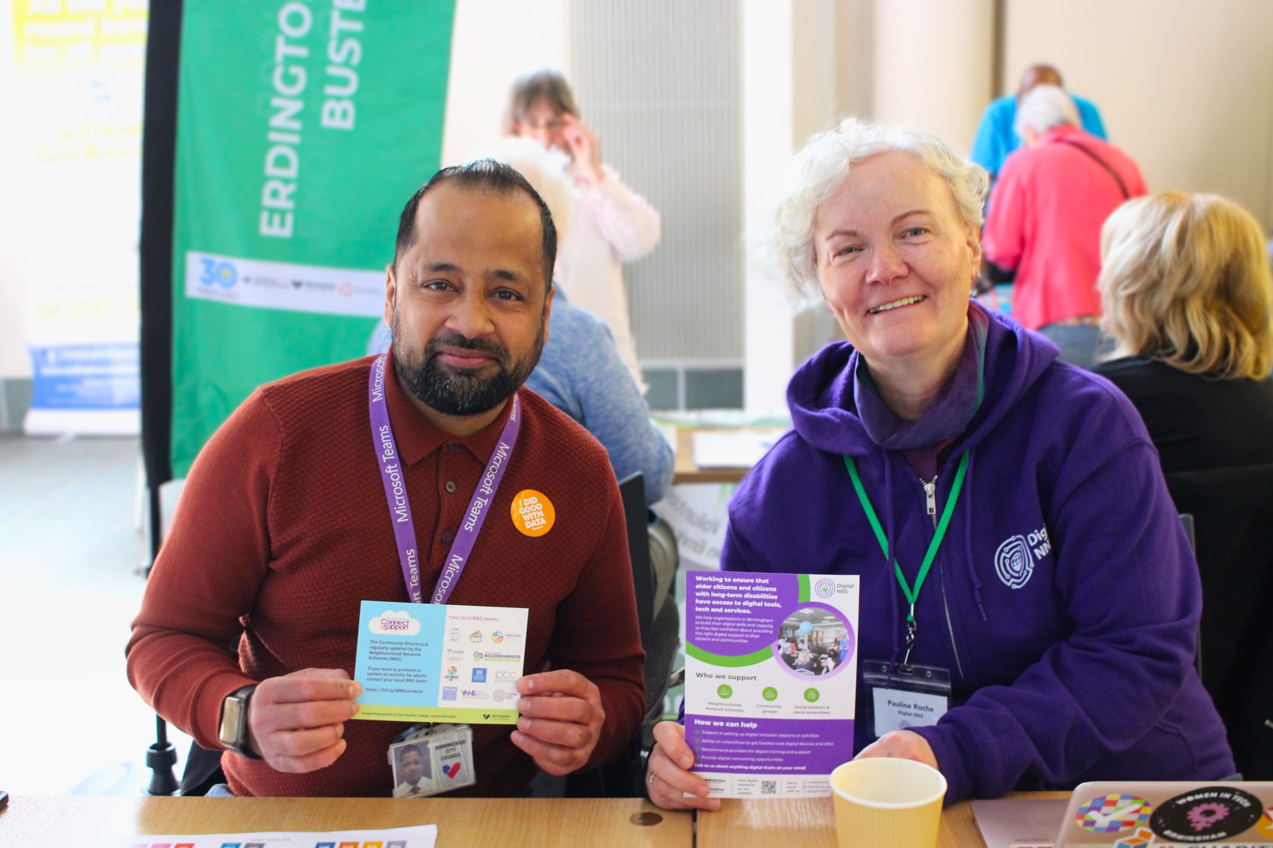 Two people holding up information regarding Connect2Support